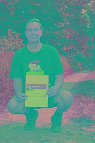Mann posiert in der Hocke mit MUKOmove-Startnummer und MUKOmove-T-Shirt