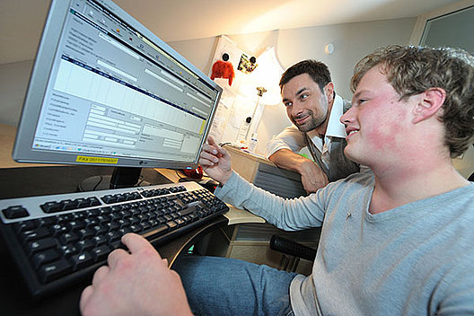 Zwei Männer vor einem Computer