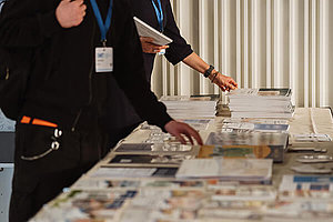 Hände greifen nach Informationsbroschüren am Infostand des Mukoviszidose e.V. 