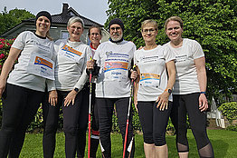 Gruppe mit weißen T-Shirts, Walkingstöcken und MUKOmove-Startnummern