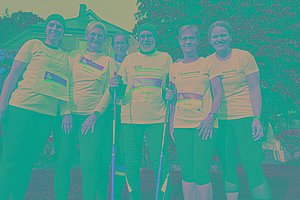 Gruppe mit weißen T-Shirts, Walkingstöcken und MUKOmove-Startnummern