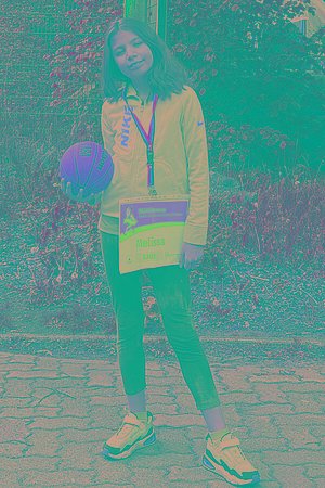 Ein Mädchen im Teenager-Alter mit Basketball und MUKOmove-Startnummer