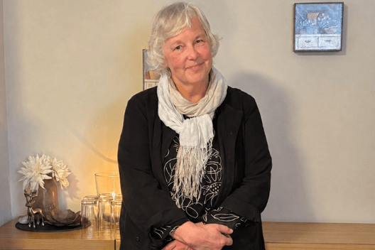 Helga Nolte Ältere Frau mit grauen Haaren schaut lächelnd in die Kamera