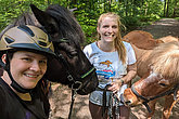 Zwei Reiterinnen zu Fuß mit ihren Pferden im Wald, eine der beiden trägt ein MUKOmove-T-Shirt