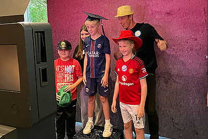 Mann und mehrere Kinder beim Fotografieren in einer Fotobox