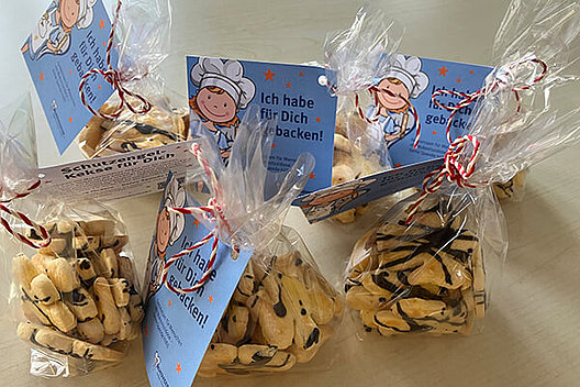 Tüten mit Schutzengelplätzchen Sechs Tüten mit Keksen, an denen ein Zettel hängt, auf dem zu lesen ist: "Ich habe für Dich gebacken"
