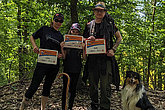 Zwei Erwachsene, ein Kind und ein Hund mit MUKOmove-Startnummern im Wald