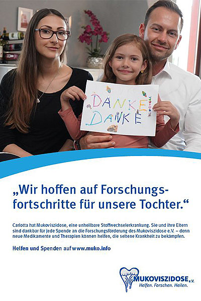 Familie (Mutter, Vater, Tochter) sitzen im Wohnzimmer, das Kind hält ein selbstgemaltes Bild in der Hand, auf dem "DANKE DANKE" steht, dazu der Text: "Wir hoffen auf Forschungsfortschritte für unsere Tochter". 