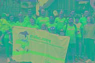 Laufteam in blauen Sport-T-Shirts posiert mit einem MUKOmove-Banner
