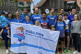 Laufteam in blauen Sport-T-Shirts posiert mit einem MUKOmove-Banner