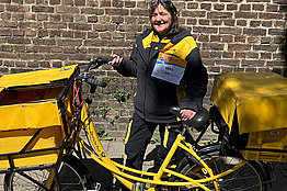 Postbotin mit Postfahrrad und MUKOmove-Startnummer