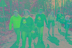 Gruppe beim Wandern im Wald, sie tragen MUKOmove-T-Shirts