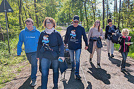Gruppe beim Wandern im Wald, sie tragen MUKOmove-T-Shirts
