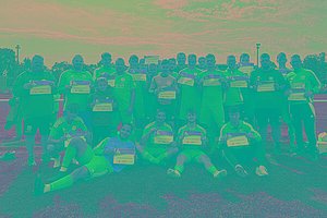 Eine Fußballmannschaft mit vorwiegend blauen Trikots posiert auf dem Fußballfeld mit MUKOmove-Startnummern. 
