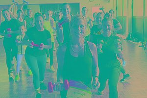 Mehrere Menschen in einem Sportraum mit Hanteln und MUKOmove-Startnummer