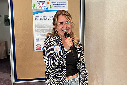 Eine Frau mit einem Mikrofon in der Hand.