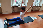 Frau auf Gymnastik-Matte mit mko.move-Shirt