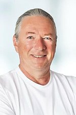Bild von Thomas Becher Portrait eines Mannes mit zusammengebundenen Haaren und einem weißen Longsleeve