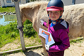 Kind streichelt Pferd - mit muko.move-Startnummer. Beim muko.move 2023 waren waren auch viele Menschen mit ihren Pferden dabei. 