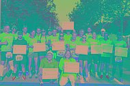 Gruppenfoto von Läufern nach dem Regensburger Marathon. Viele von ihnen haben Schilder mit der Aufschrift "Mukoviszidose braucht mehr Aufmerksamkeit - MUKOmove 2024" in der Hand