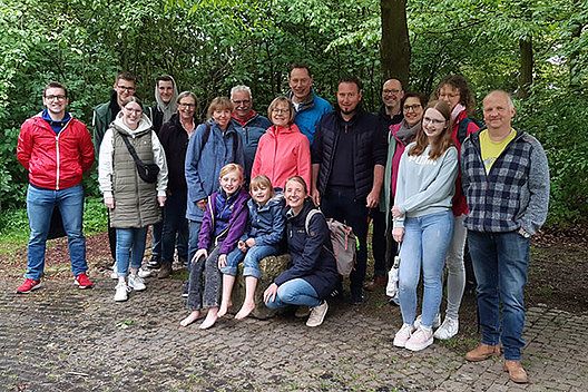 Impressionen vom Barfußgang der Regionalgruppe Münster des Mukoviszidose e.V. am 8.5.2024 anlässlich des MUKOmoves. Zu sehen ist ein Gruppenbild von Menschen, teils barfuß, im Wald. 