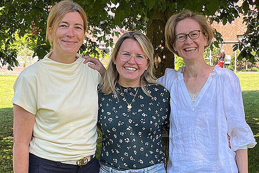 Porträt von drei Frauen im Grünen, die mittlere ist etwas jünger als die beiden außen. 