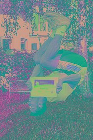 Mann schlägt einen Salto im Garten, er ist über Kopf auf dem Foto zu sehen und hält die MUKOmove-Startnummer richtig herum in die Kamera. 