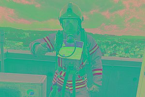 Ein Mann in Schutzkleidung wie bei der Feuerwehr hat eine Startnummer für den MUKOmove angepinnt. 
