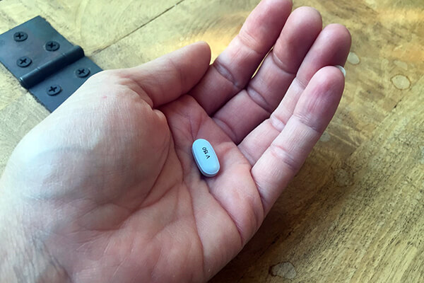 Eine Tablette Kalydeco in einer Hand