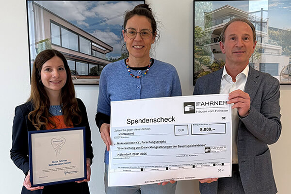 Spendenübergabe: Eine Frau in der Mitte und ein Mann neben ihr halten einen überdimensionierten Scheck über 8.000 Euro in der Hand, links daneben steht noch eine Frau. 